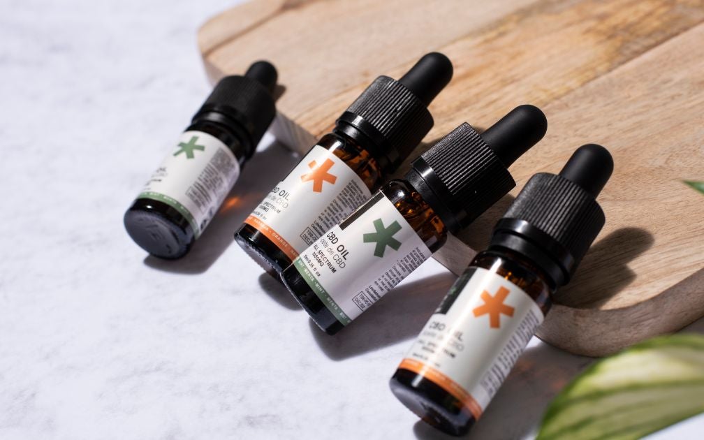 CBD oil products sitting on a wooden board.