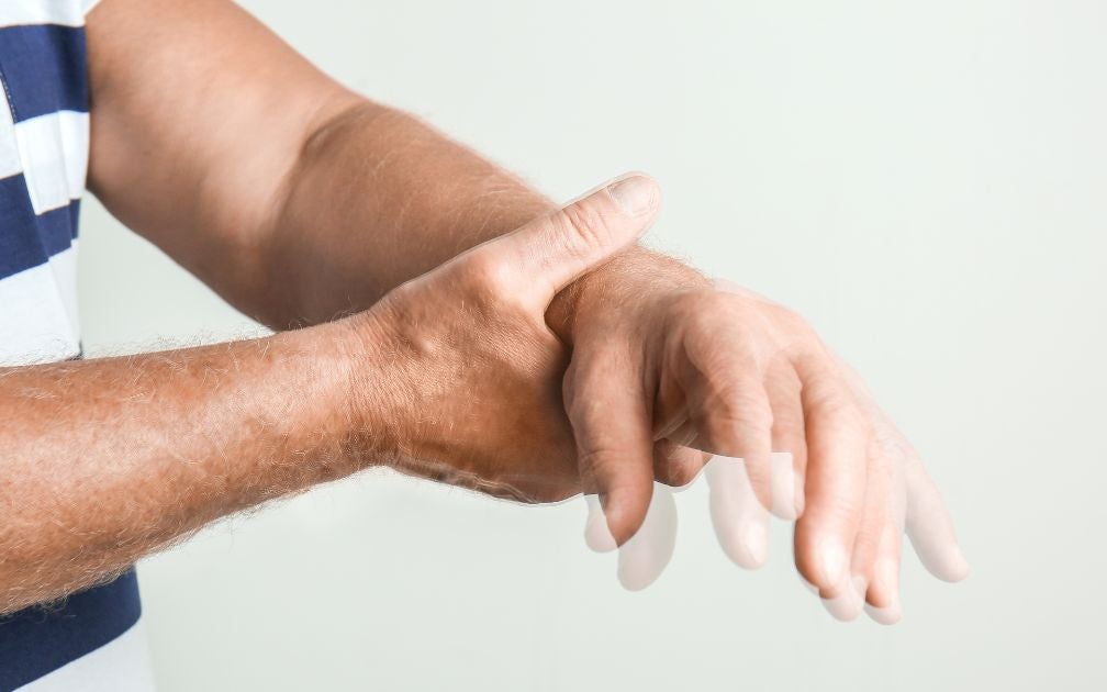 Man - hands with Parkinson - holding his hand shaking