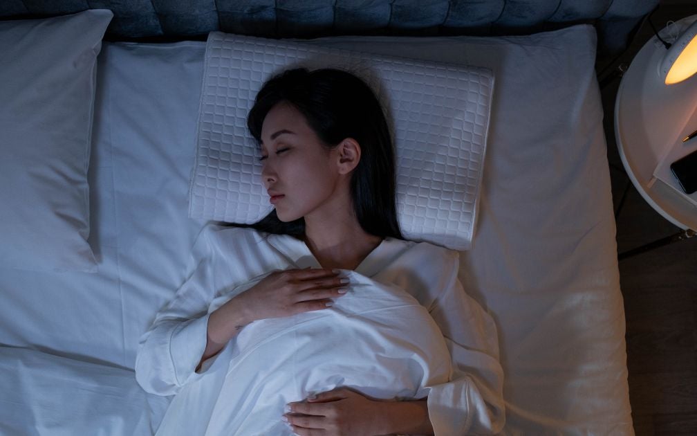 Young asian lady sleeping in a white bed.